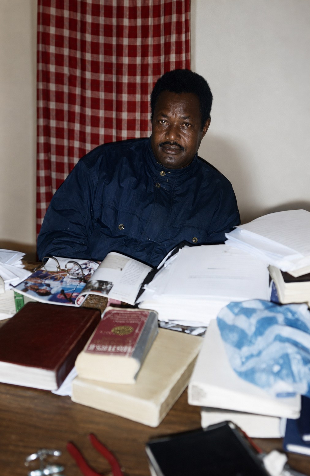 Le Pasteur Ikouba au travail, entouré de livres
